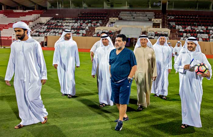 A handout picture released by the Fujairah sports club on Monday, shows Argentinian football star Diego Maradona (C) walking on the pitch at Al-Fujairah stadium upon being announced as the new head coach of the second-division Emirati side. — AFP