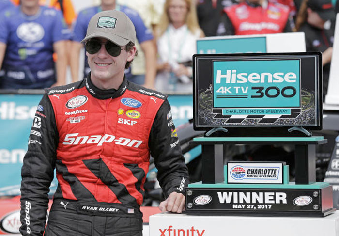 Ryan Blaney poses with the trophy in Victory Lane after winning the NASCAR Xfinity series auto race at Charlotte Motor Speedway in Concord