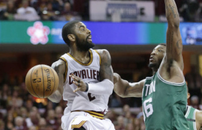 Cavaliers’ Kyrie Irving passes around Boston Celtics’ Marcus Smart during Game 4 of the NBA Eastern Conference finals in Cleveland Tuesday. — AP