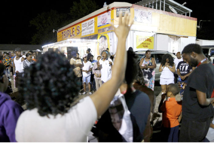 Community members gather during a vigil at the Triple S Food Mart after the US Justice Department announced they will not charge two police officers in the 2016 fatal shooting of Alton Sterling, in Baton Rouge, Louisiana, on Tuesday. — Reuters
