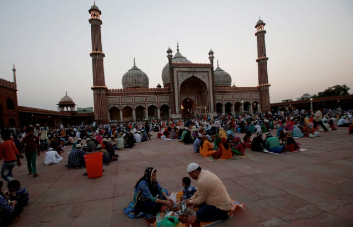 Muslims eat their iftar (breaking fast) meal at the Jama Masjid in the old quarters of Delhi. — Reuters