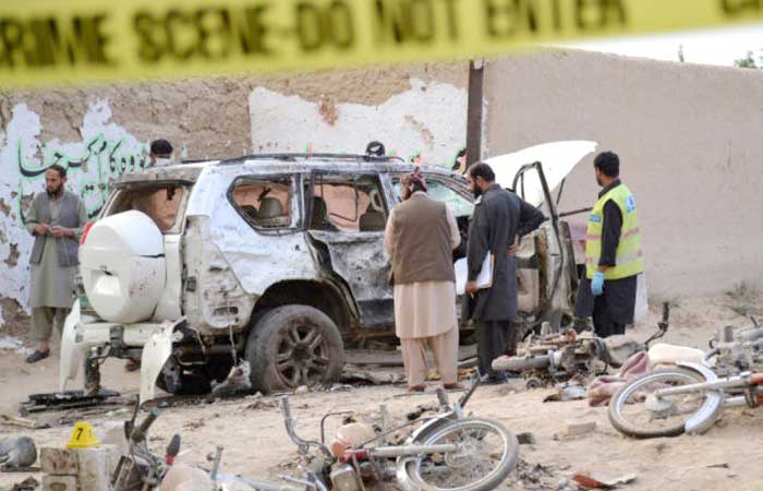 Security officers collect evidence as they investigate crime scene after a bomb exploded next to a convoy of deputy chairman of the Pakistan Senate, Senator Ghafoor Haideri, in Mastung, Pakistan, on Friday. — Reuters