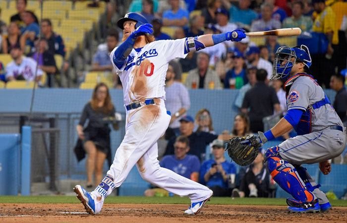 Los Angeles Dodgers' Justin Turner watches his solo home run in front of New York Mets catcher Travis d'Arnaud during their MLB game in Los Angeles Thursday. — AP