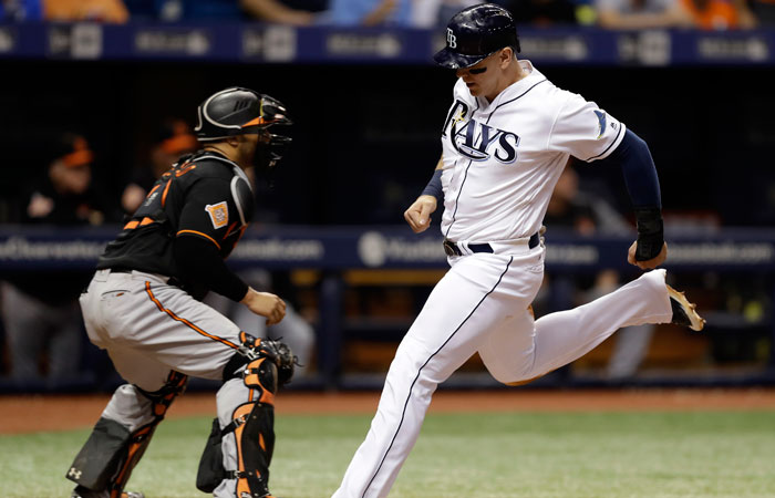 Tampa Bay Rays' Logan Morrison (R) races home to score in front of Baltimore Orioles’ catcher Welington Castillo during their MLB game in St. Petersburg, Fla., Friday. — AP