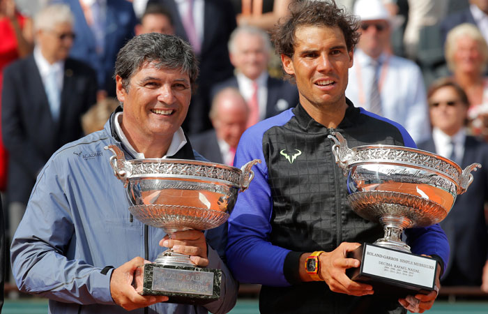 Spain's Rafael Nadal (R) poses with the special Decima Cup while his uncle Toni Nadal holds the men's winner’s cup after the final match of the French Open Tennis Tournament at the Roland Garros Stadium in Paris Sunday. — AP  