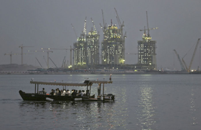 A passenger boat crosses a lagoon close to the Ras Al Khor Wildlife Sanctuary in Dubai with the construction for the Dubai Creek Harbor project in the background. — AP photos