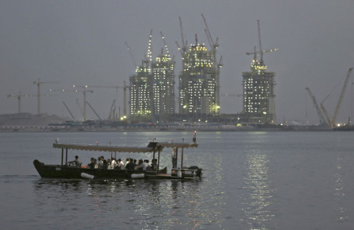A passenger boat crosses a lagoon close to the Ras Al Khor Wildlife Sanctuary in Dubai with the construction for the Dubai Creek Harbor project in the background. — AP photos