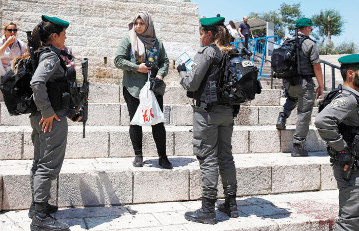 Israeli border guards question a Palestinian woman outside Damascus Gate in Jerusalem’s Old City. — AFP