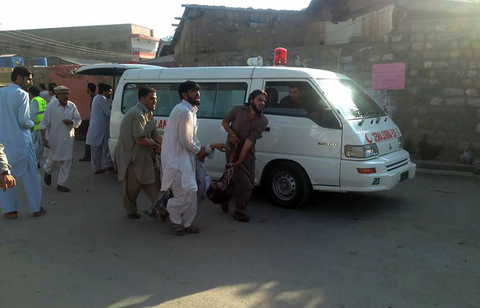 Pakistani residents carry an injured man after a twin blasts at a market in Parachinar, capital of Kurram tribal district, on Friday. — AFP