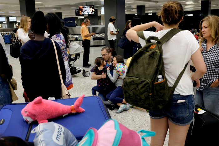 Ahmed Khalil, an Egyptian national residing in the United States, hugs and kisses his daughters Laila, 6 (left), and Farida, 8 (right), as they arrive at Washington Dulles International Airport in the hour after the Trump administration's travel ban was allowed back into effect pending further judicial review, in Dulles, Virginia, on Thursday evening. — Reuters.