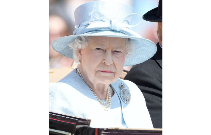Britain’s Queen Elizabeth II travels in a horse-drawn carriage past Buckingham Palace on her way to Horse Guards Parade for the Queen’s Birthday Parade in London on Saturday. — AFP