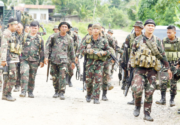 Philippine soldiers patrol a road at Pigkawayan, a farming town about 160 kmfrom Marawi city, on north Cotabato, in the southern Philippine island of Mindanao on Wednesday. — AFP