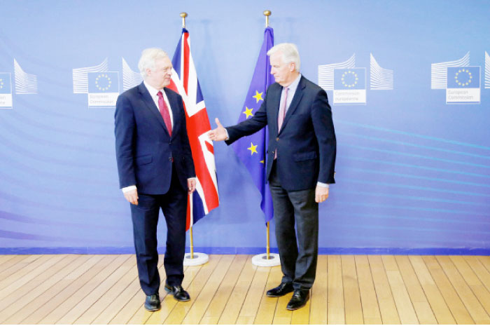 The European Union’s chief Brexit negotiator Michael Barnier, right, welcomes Britain’s Secretary of State for Exiting the European Union David Davis at the European Commission ahead of their first day of talks in Brussels on Monday. — Reuters
