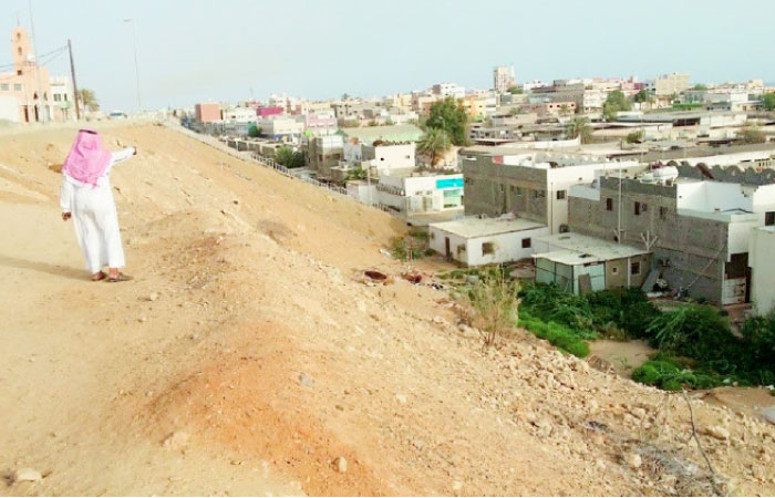 A citizen points to the landfill taking waste from nearby places in Al-Samda neighborhood in Diba. — Okaz photo