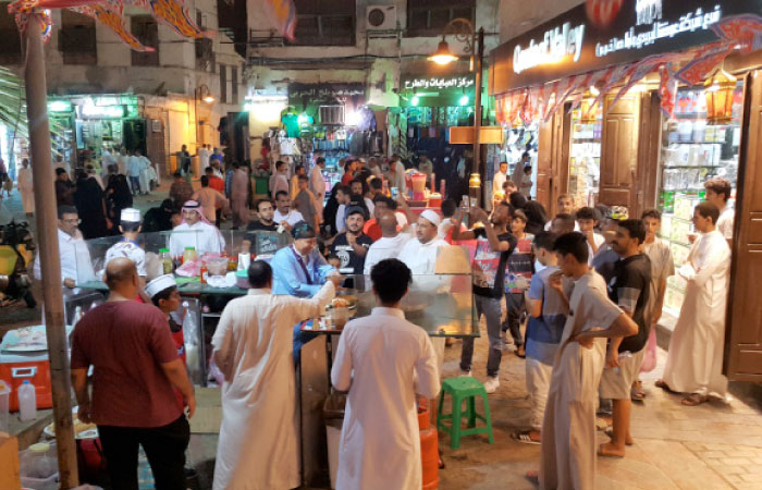 Wajnat Rahbini surrounded by her fans while making fried liver. — SG photos by Saleh Fareed