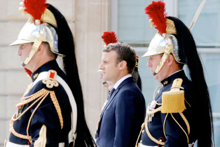 French President Emmanuel Macron waits for guests to leave at the Elysee Palace in Paris, France, on Monday. — Reuters