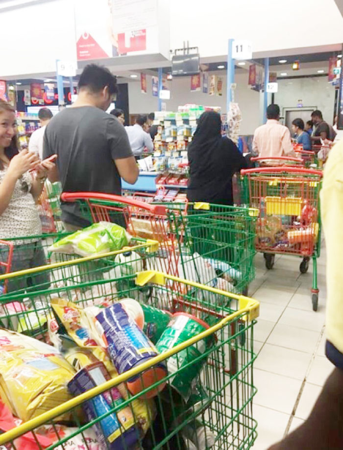 People are seen buying food staples at a supermarket in Doha on Monday. A local news website in Qatar reported some citizens and residents already had begun swarming grocery stores. It said some stores had begun seeing their shelves empty over fears that the crisis could see groceries run out of products. — AP
