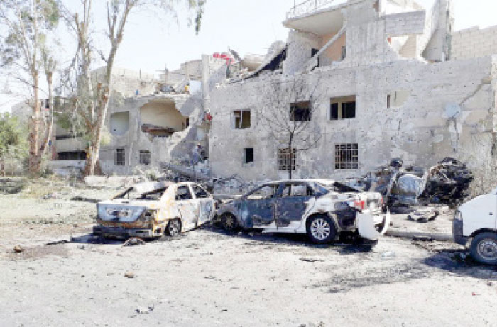 Several damaged cars are seen along the road to the airport in southeast Damascus on Sunday. — AP