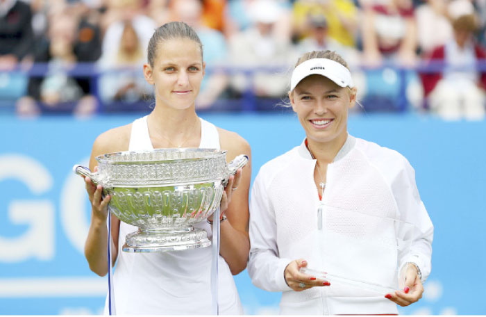 Czech Republic’s Karolina Pliskova (L) holds the trophy with runner-up Denmark’s Caroline Wozniacki at the Aegon International Tennis Tournament in Eastbourne Saturday. — AP
